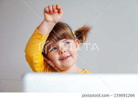 Three year old girl in yellow talking on a smartphone, concept of internet safety 139091266