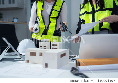 Architect woman working with blueprints for sketching a construction project, green energy and solar panel concept. 139091407