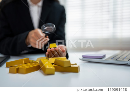 Gold investment concept with businesswoman analyzing market data on tablet, stack of gold bars. Gold investment concept with businesswoman analyzing market data on tablet, stack of gold bars. 139091458