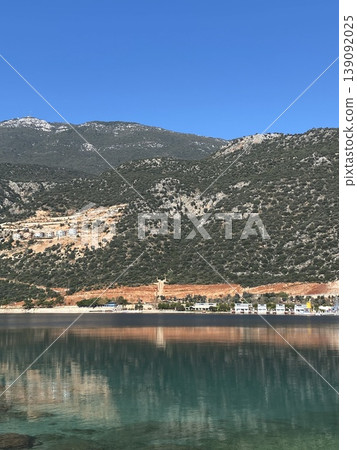 Coastal landscape with mountains, trees, and clear blue sky, ideal for background or travel concept Coastal landscape with mountains, trees, and clear blue sky, ideal for background or travel concept 139092025
