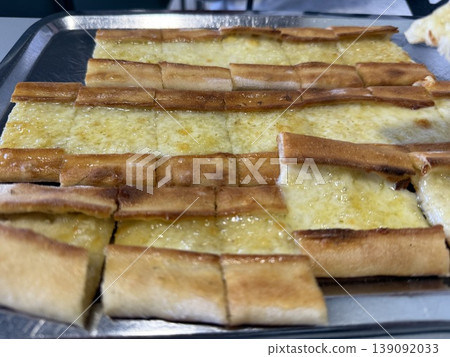 Traditional Turkish cheese pide on metal tray showcasing delicious flatbread variety Traditional Turkish cheese pide on metal tray showcasing delicious flatbread variety 139092033