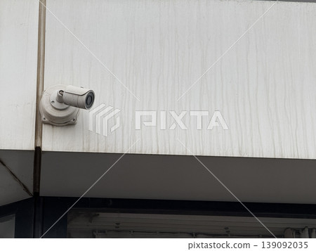 Surveillance camera on wall outside building used for security and monitoring observations 139092035