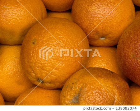 Oranges piled closely in a textured background highlighting vibrant orange color Oranges piled closely in a textured background highlighting vibrant orange color 139092074