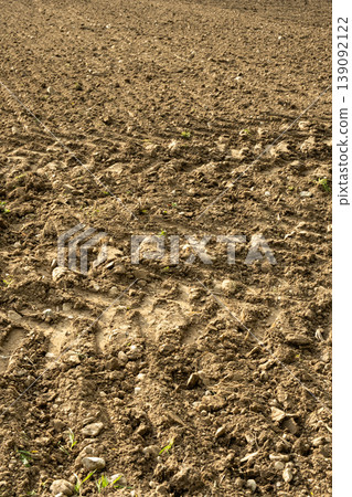 A farmers field with many stones. Natural soil surface with pebbles. A farmers field with many stones. Natural soil surface with pebbles. 139092122
