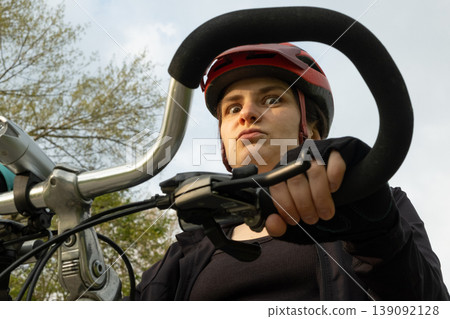 Portrait of a funny female cyclist in a helmet close-up Portrait of a funny female cyclist in a helmet close-up 139092128