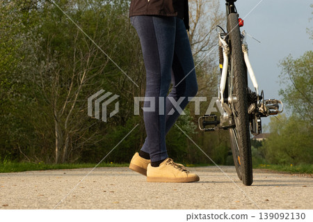 Low angle shot of cyclists legs standing next to a bicycle 139092130