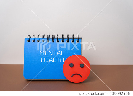 Mental health concept. Emotional, psychological, and social well-being, influencing cognition, perception, and behavior. Depression, anxiety disorder. Notepad and angry smiley face 139092506