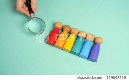A hand holds a magnifying glass near a person representing the LGBT community. 139092536