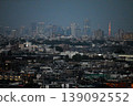 The Odakyu Line runs with the Tokyo city center as dusk falls behind it. 139092552