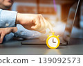 Businessman presses a stopwatch and an alarm clock while sitting in an office at a laptop. Concept of deadline pressure, time management, urgency, productivity, multitasking, and work efficiency 139092573