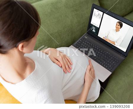 Pregnant woman having online consultation with her gynecologist. Doctor explain result of analysis to her patient using video chat. Stay home 139093208