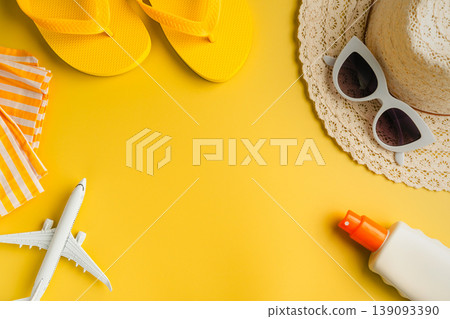 Summer background. Sunglasses, beach flip-flops, sunscreen, sun hat and airplane. Yellow background with copy space. Summer background. Sunglasses, beach flip-flops, sunscreen, sun hat and airplane. Yellow background with copy space. 139093390