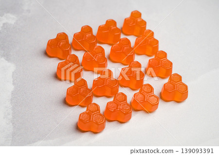 Orange vitamins jelly gummies on bright background, food supplements, top view 139093391