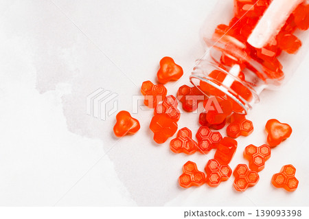 Jelly gummies close-up, fruit vitamins on bright background, food supplements.Orange vitamins in a jar, copy space 139093398