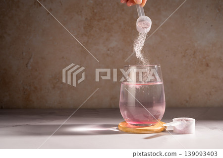 Pouring food supplement powder in glass of water. Collagen, protein powder, vitamins. Pouring food supplement powder in glass of water. Collagen, protein powder, vitamins. 139093403