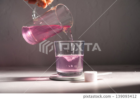 Pouring food supplement powder in glass of water. Collagen, protein powder, vitamins. Pouring food supplement powder in glass of water. Collagen, protein powder, vitamins. 139093412