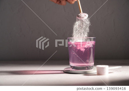 Pouring food supplement powder in glass of water. Collagen, protein powder, vitamins. Pouring food supplement powder in glass of water. Collagen, protein powder, vitamins. 139093416