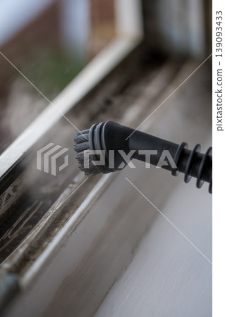 Cleaning the window. Steam device removes dirt from the plastic window frame. Cleaning the window. Steam device removes dirt from the plastic window frame. 139093433