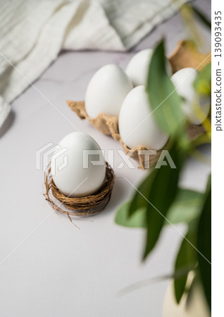 Easter spring background. Egg in a nest. Eggs box with eucalyptus green leaves. Minimalistic Easter spring background. Egg in a nest. Eggs box with eucalyptus green leaves. Minimalistic 139093435