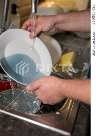 A man washing dishes in the kitchen, home chores, daily routine 139093450