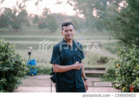 Relaxed man enjoying countryside view in rice field Relaxed man enjoying countryside view in rice field 139093603