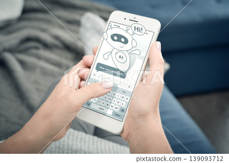Cute AI assistant chatbot on smartphone screen, woman using mobile phone at home. Virtual support concept. 139093712