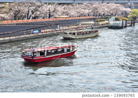 A cherry blossom viewing cruise ship sailing down the Sumida River A cherry blossom viewing cruise ship sailing down the Sumida River 139093765