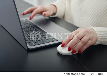 Close up of female hands with red manicure typing on a laptop keyboard. 139093806