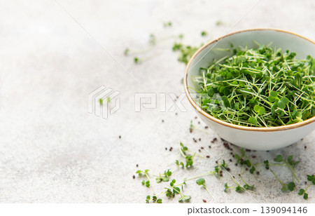 Fresh green microgreens in a bowl on a light surface Fresh green microgreens in a bowl on a light surface 139094146