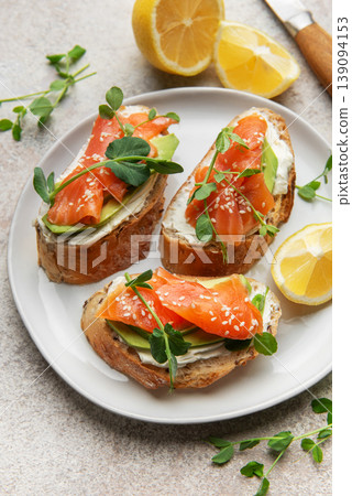 Salmon avocado bruschetta with cream cheese and microgreens Salmon avocado bruschetta with cream cheese and microgreens 139094153
