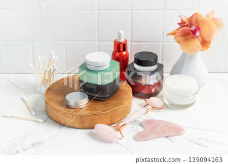 Skincare product bottles with jade roller and orchid Skincare product bottles with jade roller and orchid 139094163