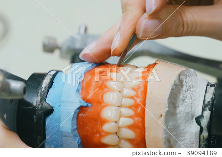 Crafting precision dentures in a busy dental technician workshop 139094189