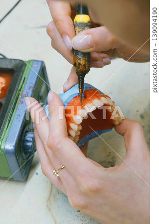 Crafting custom dentures with precision and skill in dental workshop 139094190