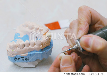 Expert dental technician crafting precise dentures with careful attention Expert dental technician crafting precise dentures with careful attention 139094199