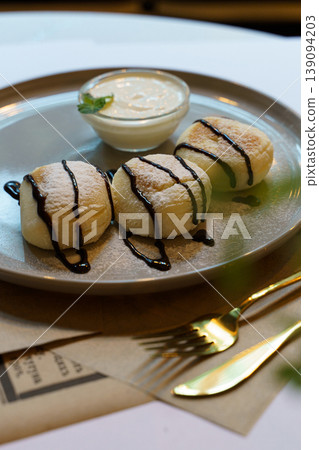 Delicate dessert plated elegantly with chocolate drizzle and cream 139094203