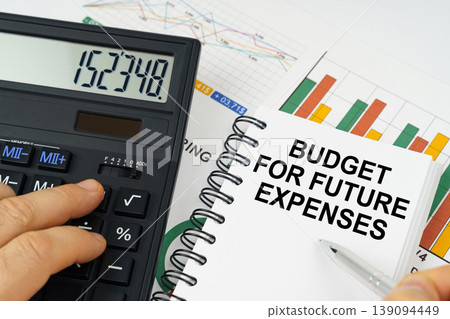 On the table there is a calculator, reports with graphs and a notepad with the inscription - Budget for future expenses On the table there is a calculator, reports with graphs and a notepad with the inscription - Budget for future expenses 139094449