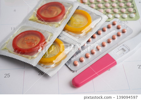 Pregnancy test and condom for female on calendar, ovulation day. Pregnancy test and condom for female on calendar, ovulation day. 139094597