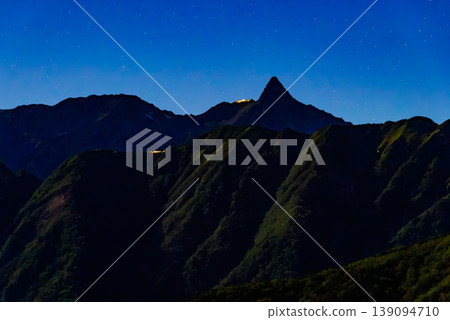 Northern Alps, Mt. Yarigatake, Night View: The peak of Mt. Yarigatake illuminated by moonlight and the lights of Yarigatake Mountain Hut. Northern Alps, Mt. Yarigatake, Night View: The peak of Mt. Yarigatake illuminated by moonlight and the lights of Yarigatake Mountain Hut. 139094710