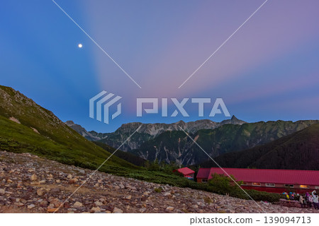北阿爾卑斯山:黎明時分的槍穗高山脈,晨曦和月光照亮了莊年小屋的景色。 北阿爾卑斯山:黎明時分的槍穗高山脈,晨曦和月光照亮了莊年小屋的景色。 139094713