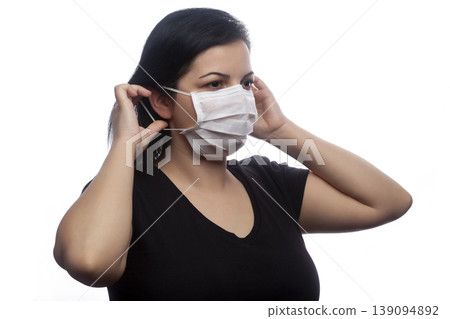 Woman wearing a white mask. Woman wearing a white mask. 139094892