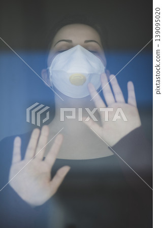 A woman staying at home in quarantine and watching the outside world through the window A woman staying at home in quarantine and watching the outside world through the window 139095020