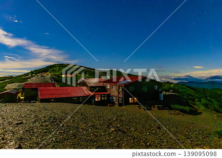 Night view of Chogatake Hutte in the Northern Alps: The mountain hut and campsite lights illuminated by moonlight. Night view of Chogatake Hutte in the Northern Alps: The mountain hut and campsite lights illuminated by moonlight. 139095098