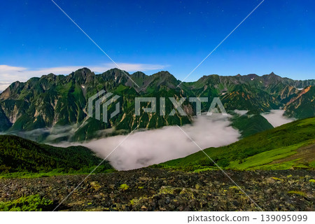 Night view from Mt. Chogatake in the Northern Alps: The Hotaka mountain range and the sea of clouds over Kamikochi illuminated by moonlight. Night view from Mt. Chogatake in the Northern Alps: The Hotaka mountain range and the sea of clouds over Kamikochi illuminated by moonlight. 139095099