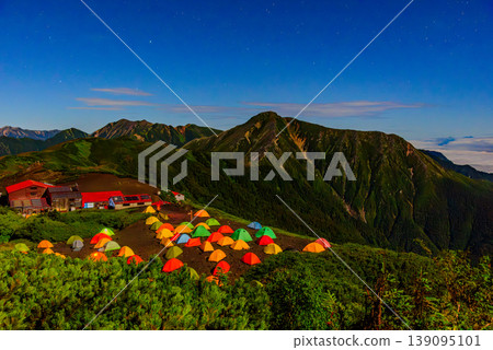 Night view of Chogatake Hutte in the Northern Alps: The campsite and the silhouette of Mt. Jonen illuminated by moonlight. Night view of Chogatake Hutte in the Northern Alps: The campsite and the silhouette of Mt. Jonen illuminated by moonlight. 139095101