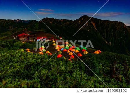 Night view of Chogatake Hutte in the Northern Alps: The campsite and the silhouette of Mt. Jonen illuminated by moonlight. 139095102