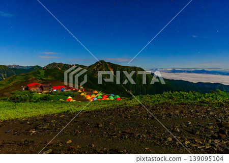Night view of Chogatake Hutte in the Northern Alps: The campsite and the silhouette of Mt. Jonen illuminated by moonlight. Night view of Chogatake Hutte in the Northern Alps: The campsite and the silhouette of Mt. Jonen illuminated by moonlight. 139095104