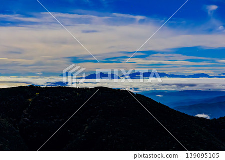 Night view from the Northern Alps: Mount Fuji and the Southern Alps floating above a sea of clouds, with lights from mountain huts. Night view from the Northern Alps: Mount Fuji and the Southern Alps floating above a sea of clouds, with lights from mountain huts. 139095105