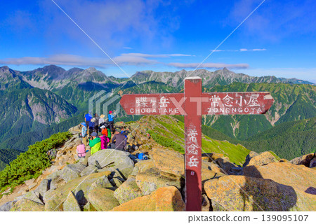 A signpost at the summit of Mt. Jonen in the Northern Alps, and climbers basking in the afterglow of their ascent of the Yari-Hotaka mountain range. A signpost at the summit of Mt. Jonen in the Northern Alps, and climbers basking in the afterglow of their ascent of the Yari-Hotaka mountain range. 139095107