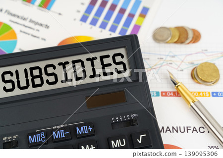On the table are financial reports, coins and a calculator with the inscription - Subsidies 139095306