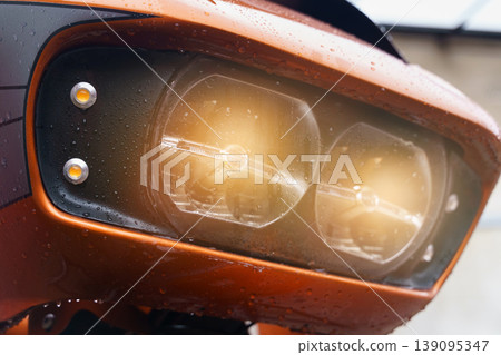 The included headlights of a motorcycle close-up, glowing yellow. 139095347